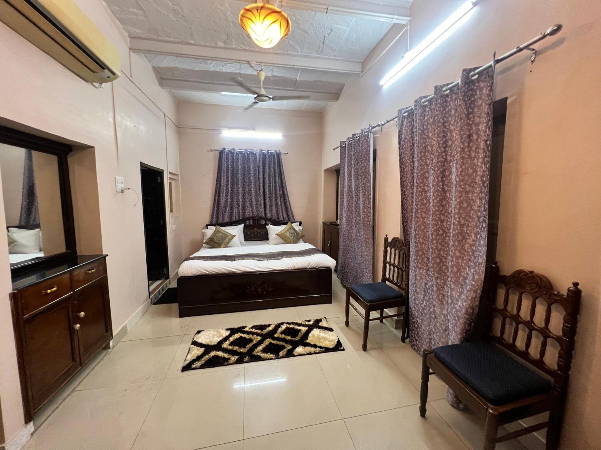 A Krishna Palace guest room in Varanasi with warm light and simple, calm furnishings